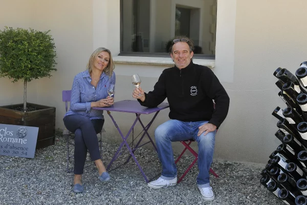 Nadine et Stéphane Charancon assis à une table en extérieur, dégustant un verre de vin au domaine