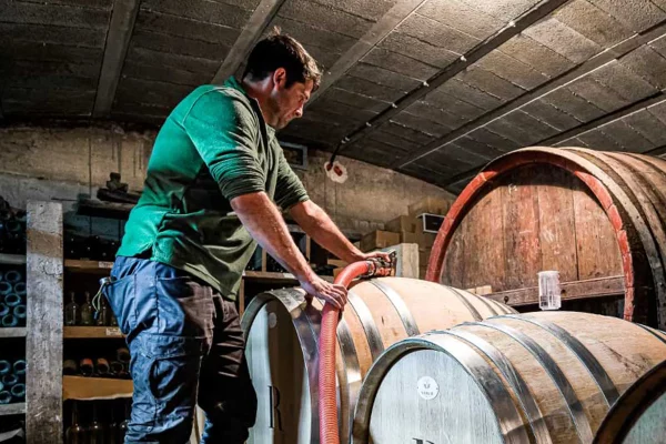 Vigneron en train de travailler sur une barrique dans une cave vinicole