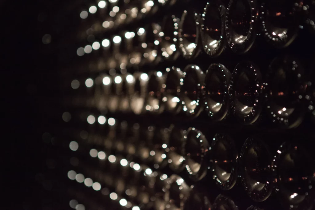 Champagne Larmandier-Bernier - Bouteilles de champagne sur lattes dans la pénombre de la cave