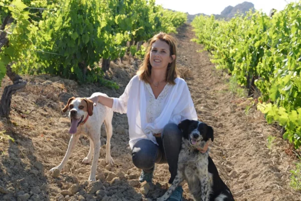 Clos Teddi - Marie-Brigitte Poli entre les rangs de vigne avec deux chiens