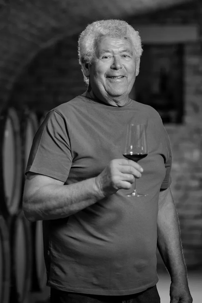 Domaine Arlaud - Hervé Arlaud, verre de rouge en main, dans la cave