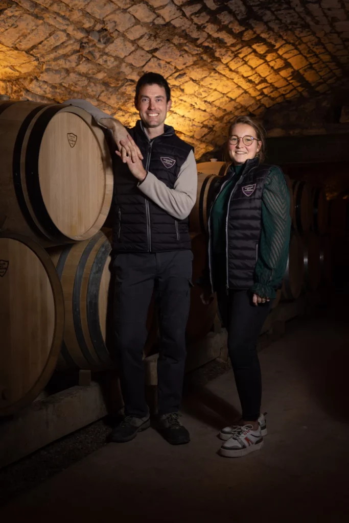 Domaine de la Vougeraie - Deux membres de l’équipe entre les fûts de la cave voûtée