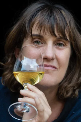 Domaine de Montbourgeau - Nicole Deriaux, verre de vin blanc en main
