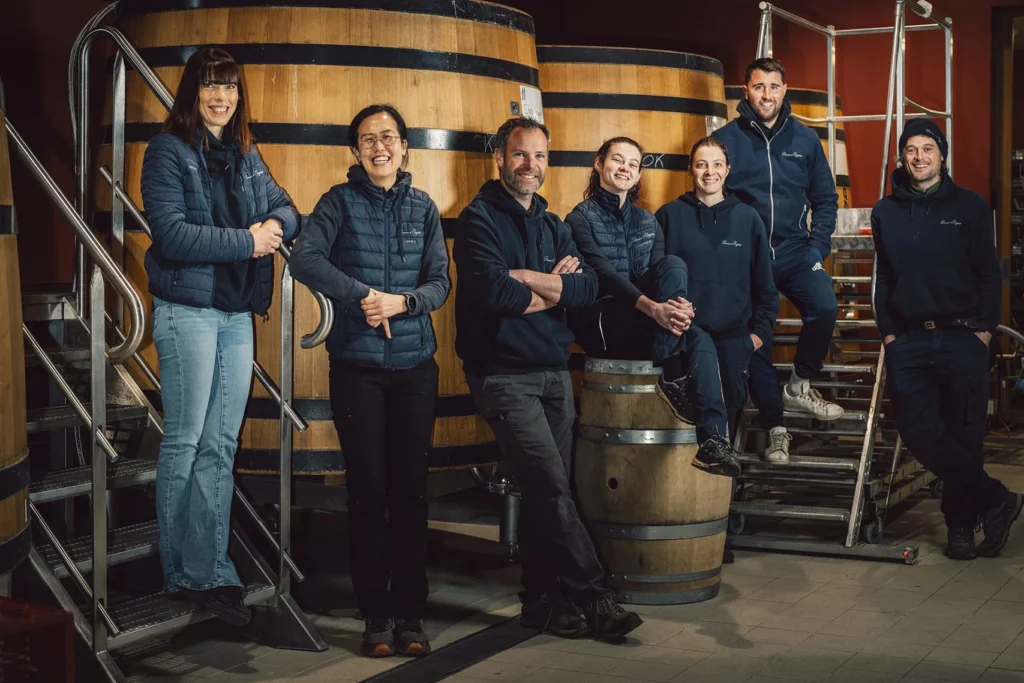 Domaine d’Eugénie - L’équipe au cuvier, devant les cuves en bois