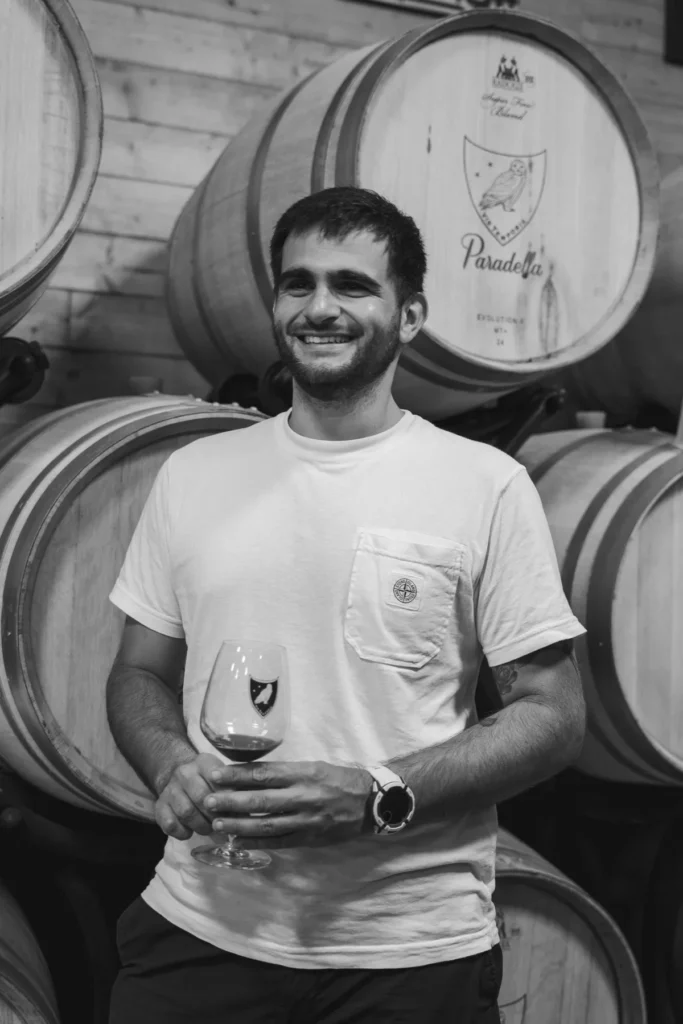 Domaine Paradella - Frédéric Mariani, verre en main, devant les barriques