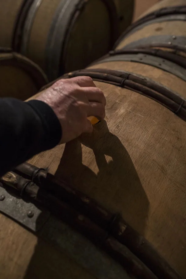 Domaine Paul Janin et Fils - Main traçant une marque à la craie sur un fût en cave