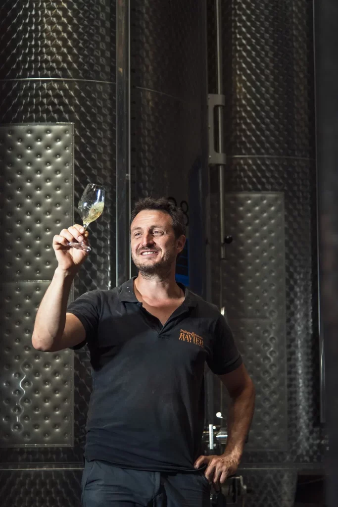 Domaine Sylvain Ravier - Vigneron levant son verre devant les cuves inox du chai