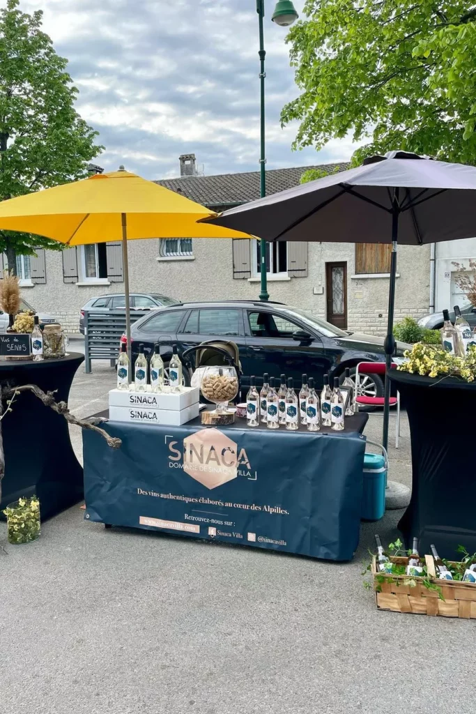 Sinaca Villa - Le stand du domaine et ses bouteilles sous les parasols