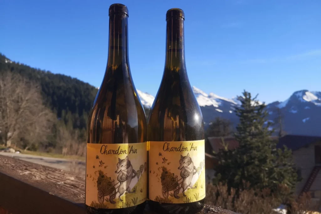 Vins Vivants - Deux bouteilles de Chardon’air et leur étiquette illustrée, face à la montagne