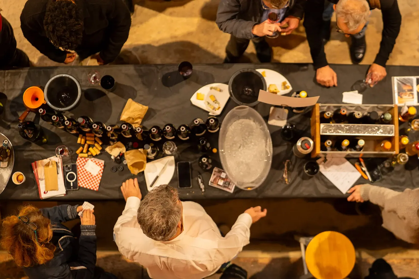 BIOTOP Montpellier - Table de dégustation vue d’en haut, bouteilles alignées et visiteurs de part et d’autre
