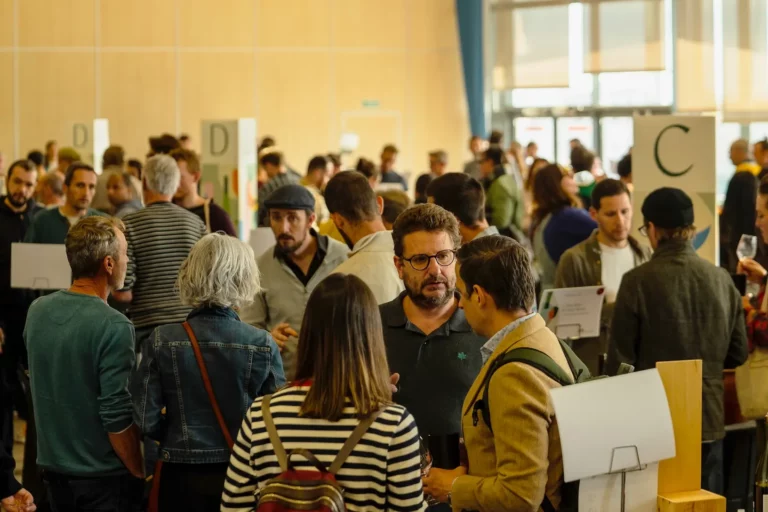 BIOTOP Toulouse - Visiteurs nombreux entre les tables de dégustation, devant de grandes baies vitrées