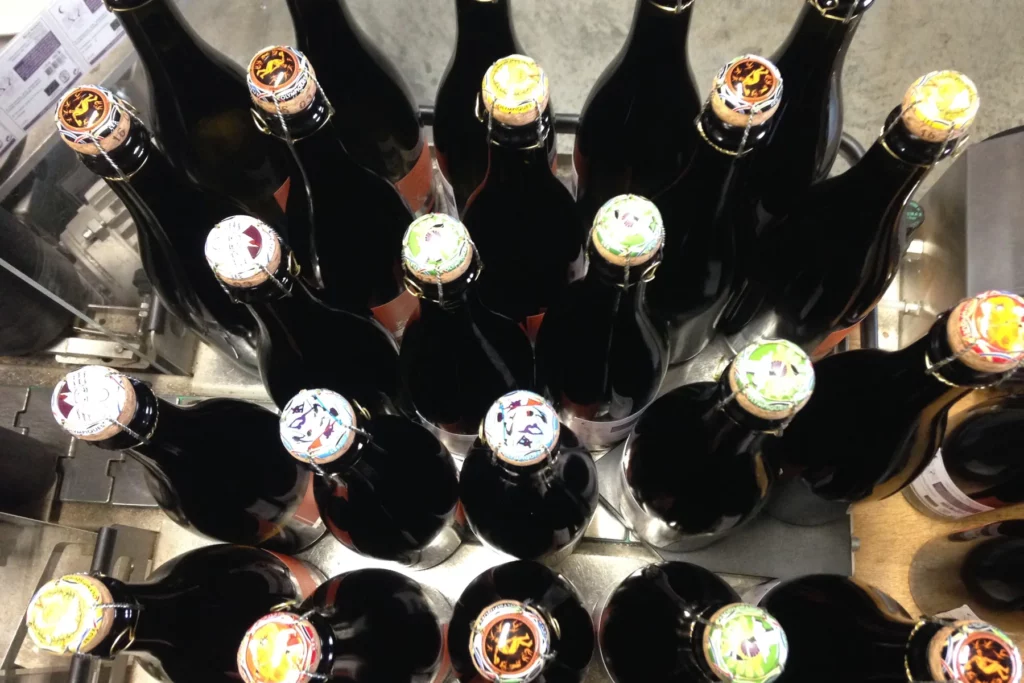Champ Divin - Bouteilles de crémant vues du dessus, plaques de muselet colorées