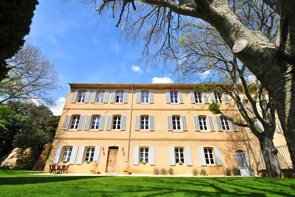 Château Bonisson - La façade de la bastide et sa pelouse ombragée