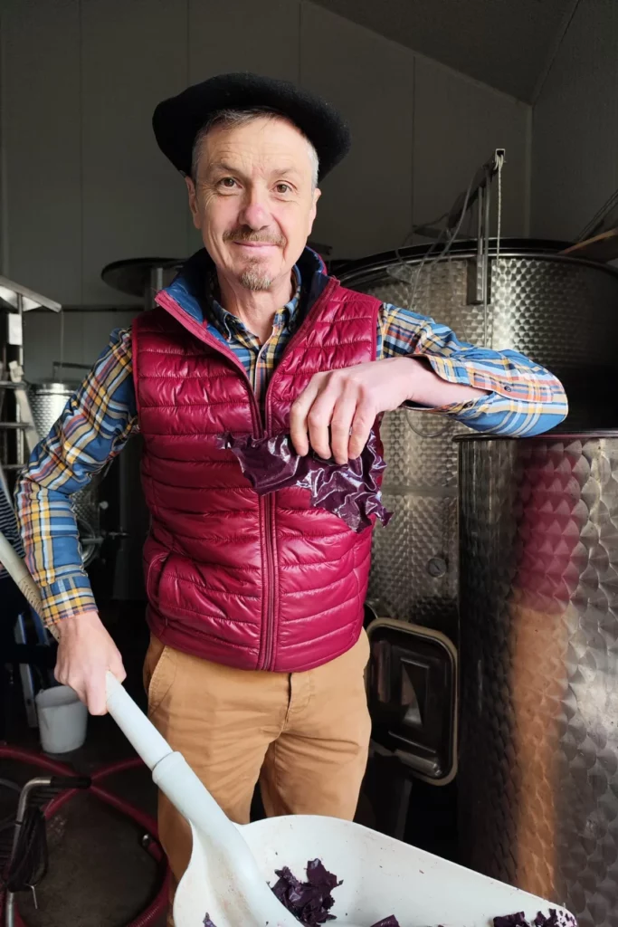 Château Cohola - Jérôme Busato au chai, pelle à la main, devant les cuves inox