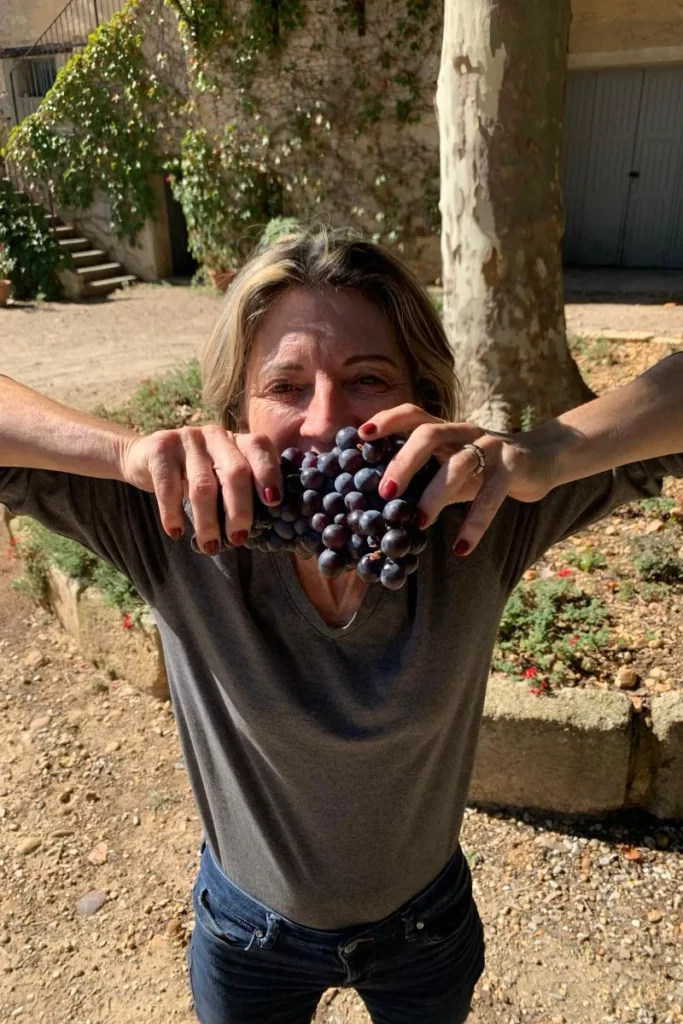 Château d'Or et de Gueules - Diane de Puymorin, une grappe de raisin noir à la main