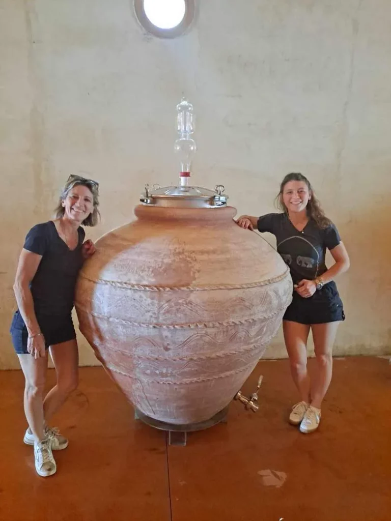 Château d'Or et de Gueules - Deux femmes près d'une grande jarre en terre cuite, dans le chai