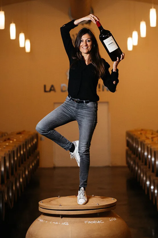 Château de La Dauphine - Stéphanie Barousse, debout sur une amphore, dans le chai à barriques