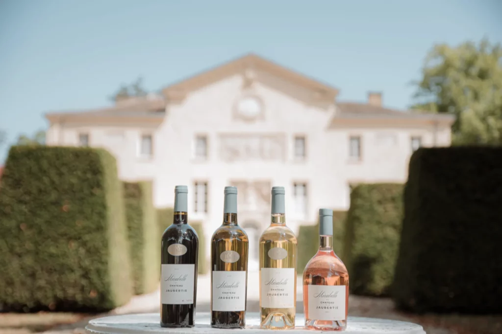 Château de la Jaubertie - Quatre bouteilles du domaine devant la façade du château
