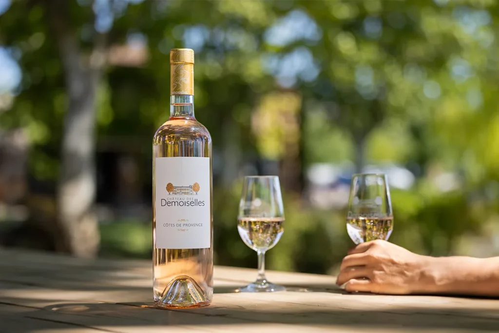 Château des Demoiselles - Une bouteille de rosé et deux verres sur une table à l’ombre