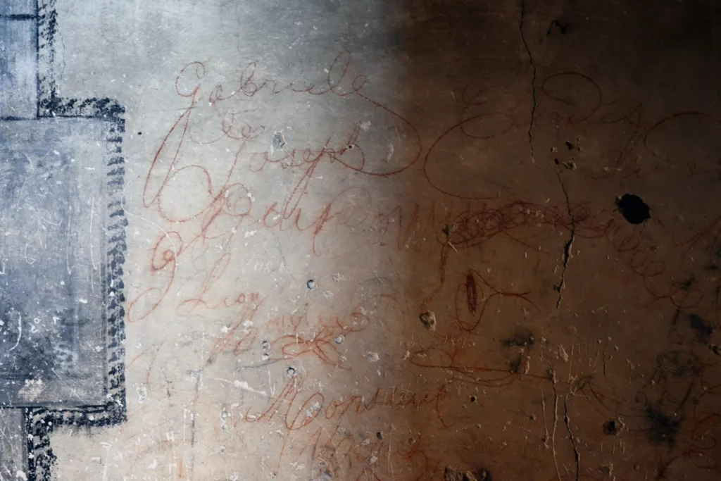 Château des Éclaz - Inscriptions anciennes tracées en rouge sur un mur intérieur