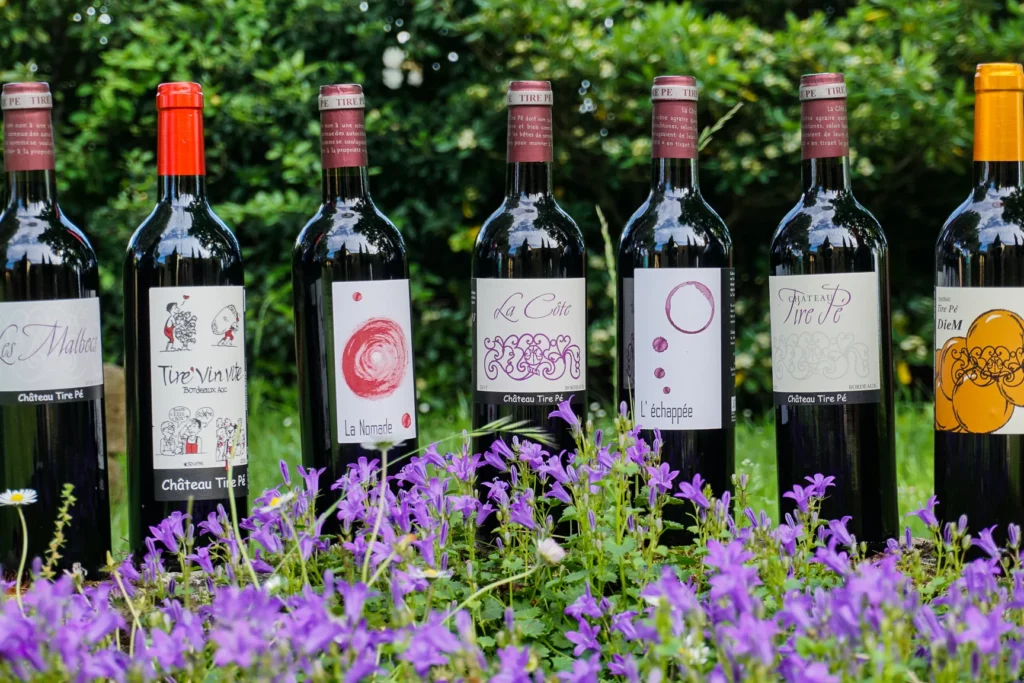 Château Tire Pé - Les bouteilles du domaine posées parmi les fleurs