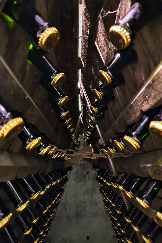 Domaine Achard-Vincent - Bouteilles capsulées couchées sur lattes dans la cave
