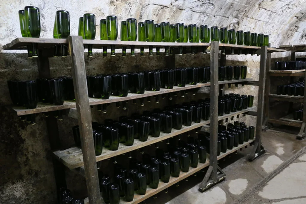 Domaine Alain Voge - Bouteilles en vieillissement sur lattes dans une cave voûtée