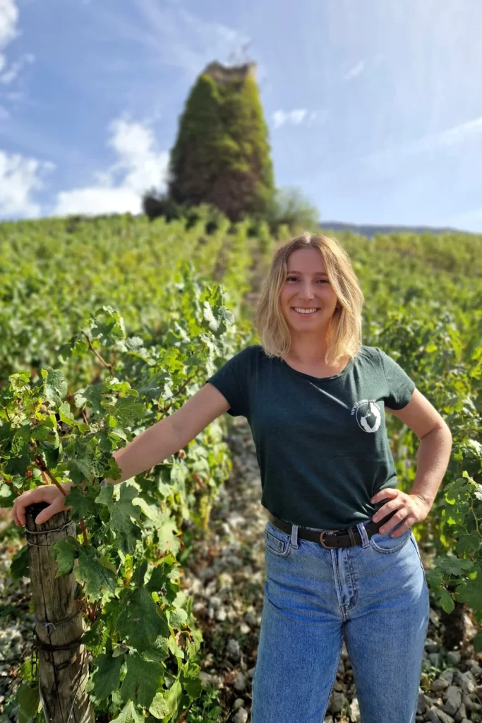 Domaine Anne-Sophie et Jean-François Quénard - Anne-Sophie Quénard dans les vignes, une tour en arrière-plan
