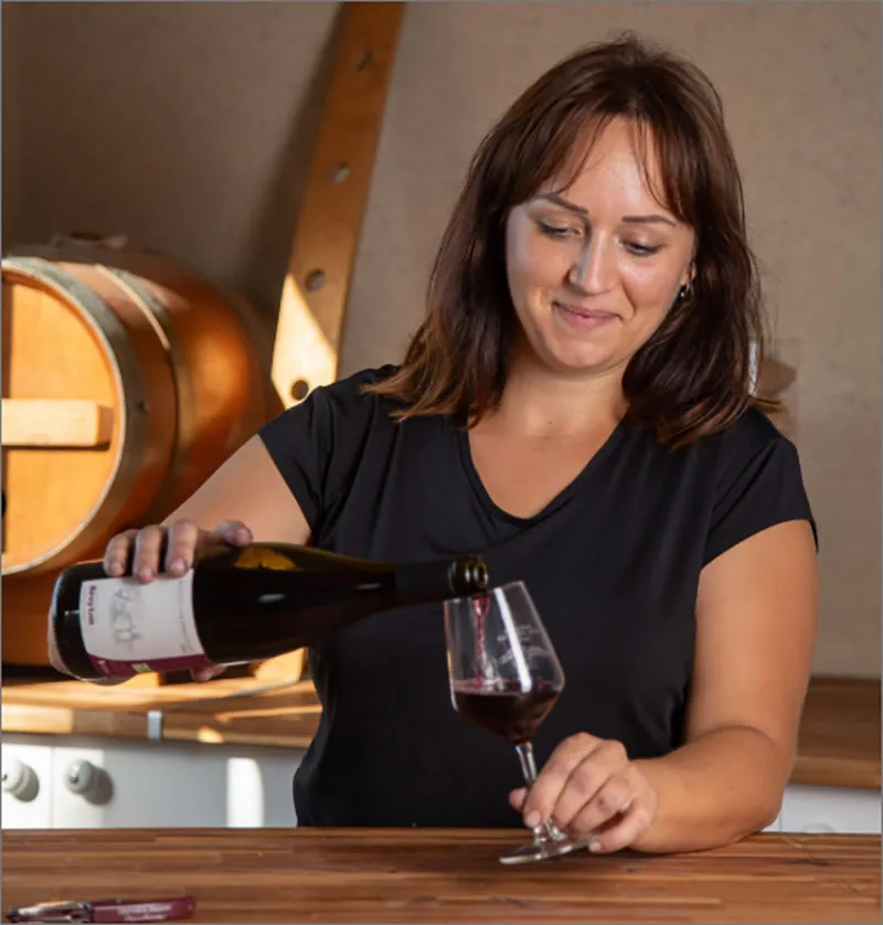 Domaine Breyton - Service d’un vin rouge au comptoir du caveau, tonneau en arrière-plan