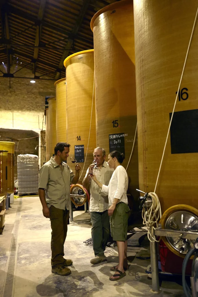 Domaine de Bannières - Trois personnes dans la cuverie, au pied des grandes cuves numérotées
