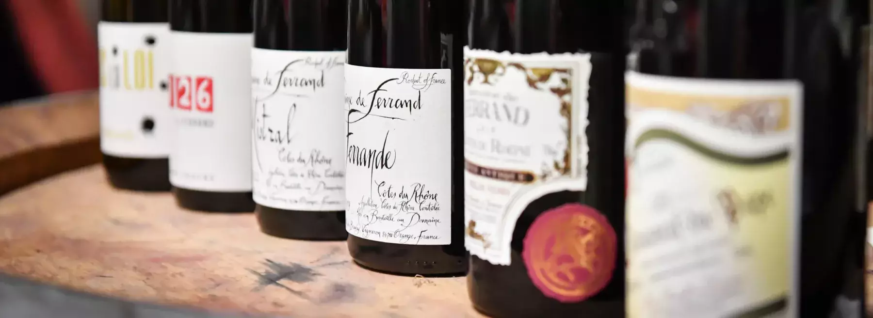 Domaine de Ferrand - Les cuvées du domaine alignées sur un fût au caveau