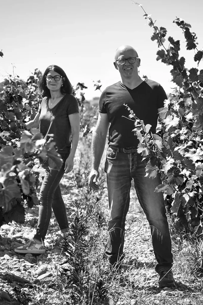 Domaine de Ferrand - Philippe et Mireille Bravay debout entre deux rangs de vigne
