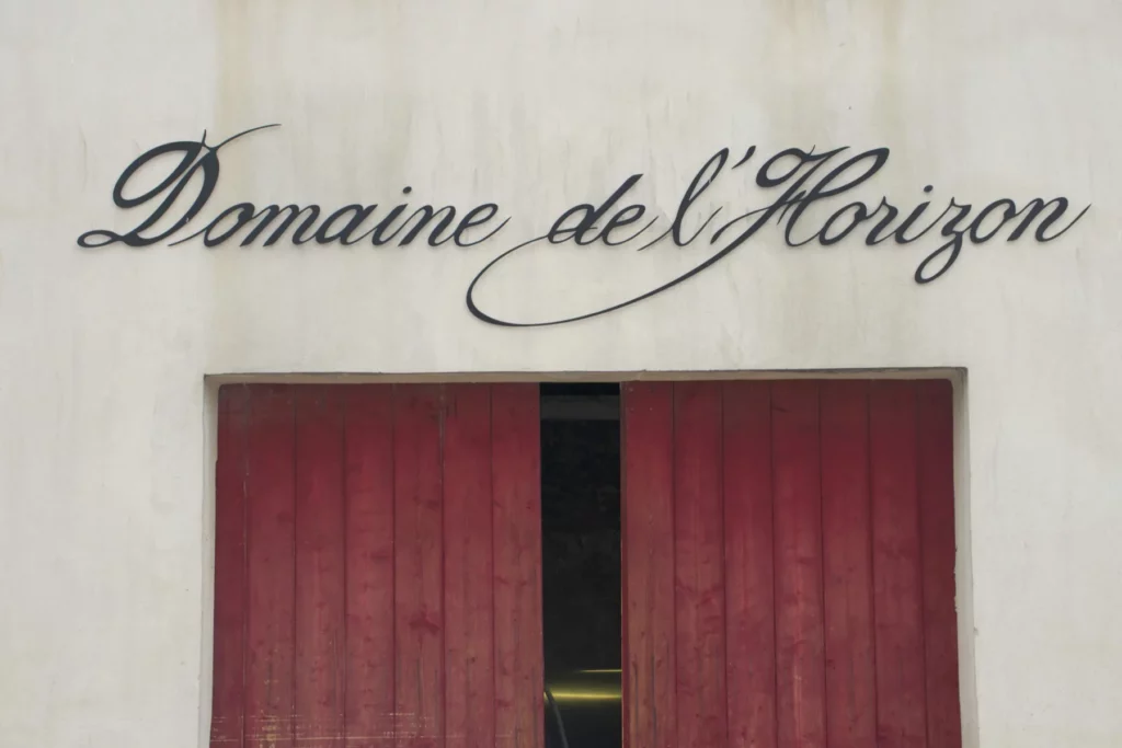 Domaine de l’Horizon - Le nom du domaine peint sur la façade, au-dessus d’une porte rouge