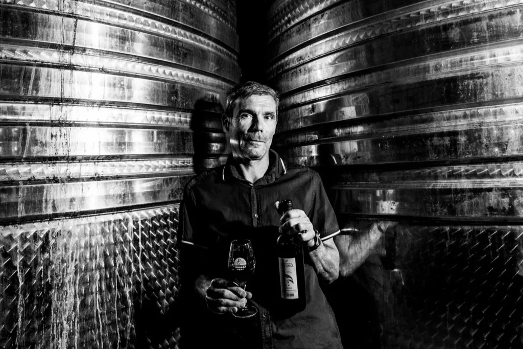 Domaine de la Patience - Christophe Aguilar entre les cuves en inox, verre et bouteille en main