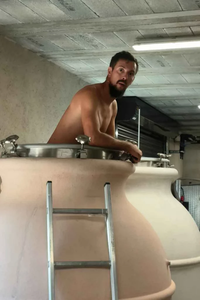 Domaine de l’Aitonnement - Maxime Dancoine au chai, penché sur une jarre