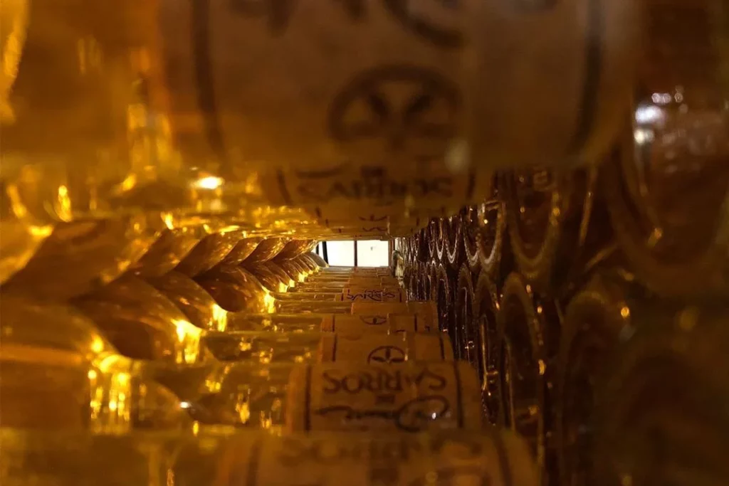 Domaine de Sarros - Bouteilles étiquetées empilées en cave
