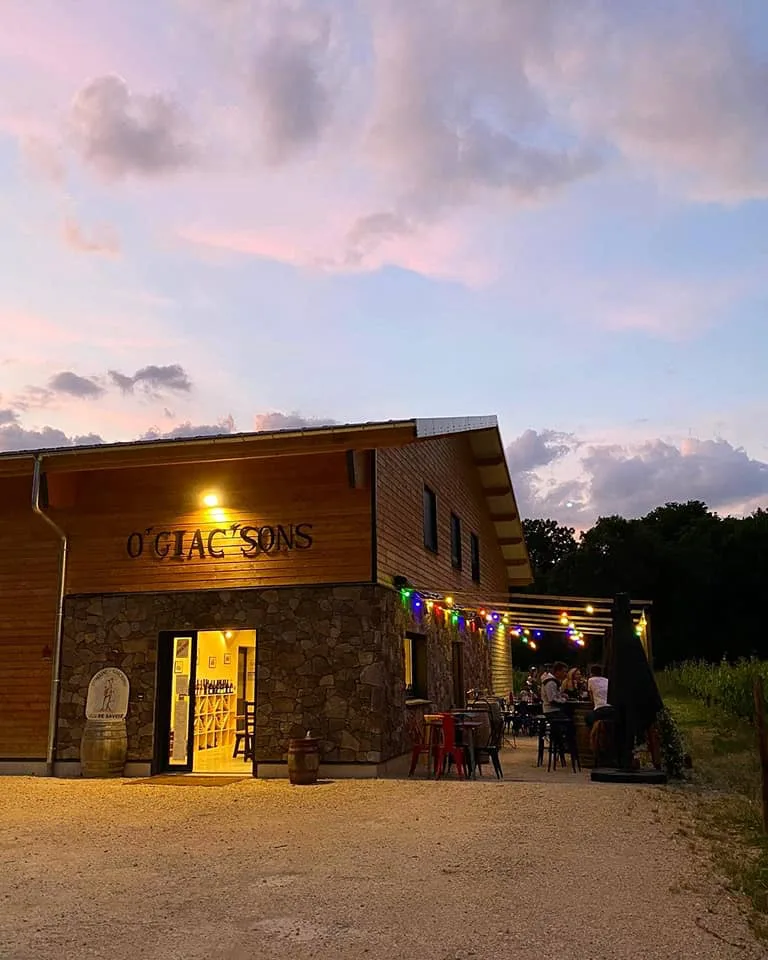 Domaine Giachino - Le bar à vin O’Giac’sons et sa terrasse éclairée au crépuscule