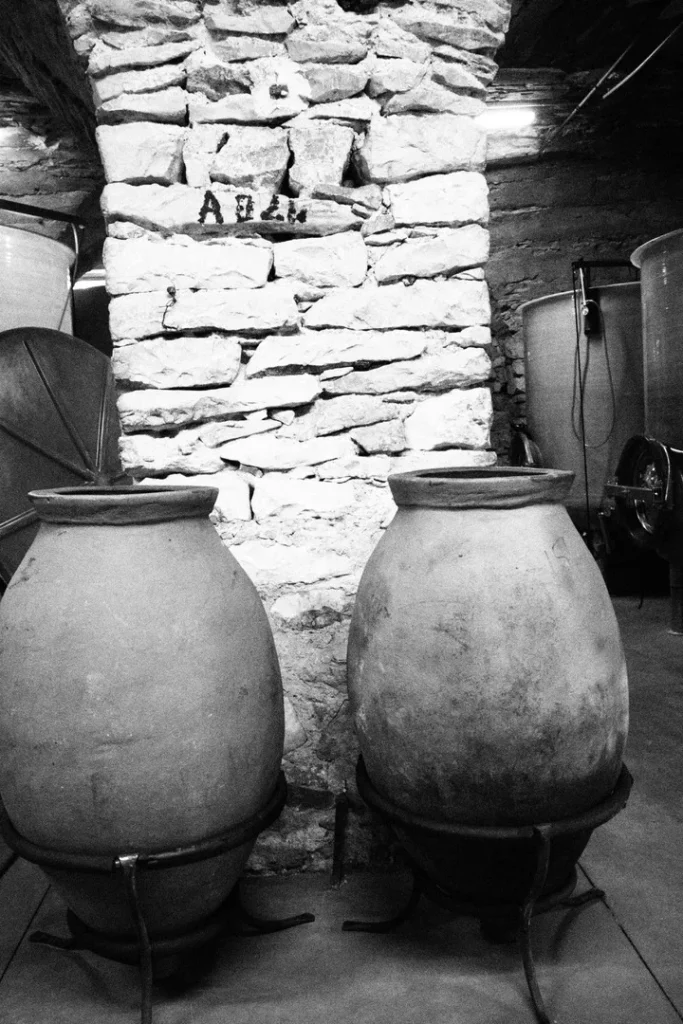 Domaine Inebriati - Deux jarres de terre cuite devant un pilier de pierre, dans le chai
