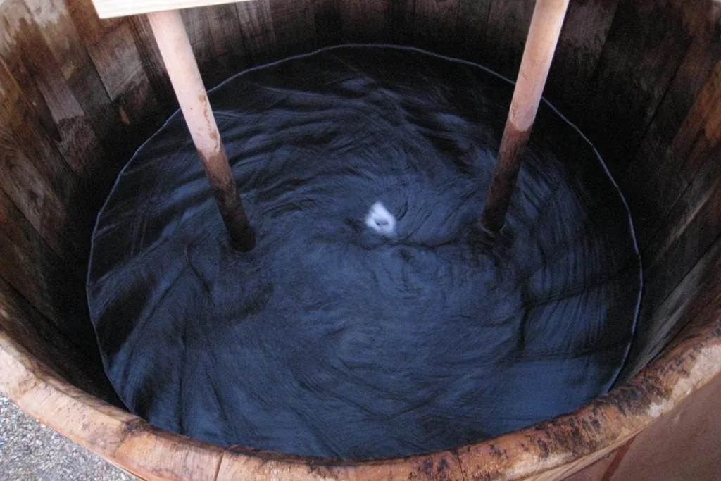 Domaine La Péquélette - Dynamisation d’une préparation biodynamique, l’eau tourne en vortex dans une cuve en bois