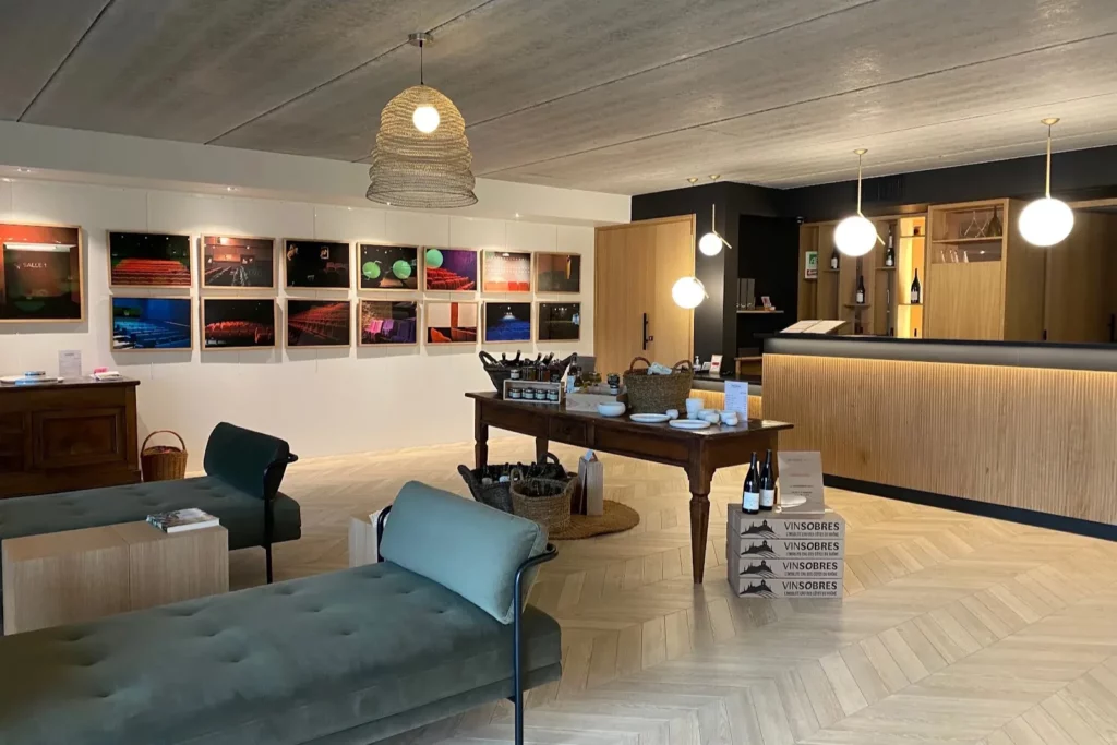 Domaine Vallot - Le salon du caveau, avec sa table de dégustation et ses photographies au mur