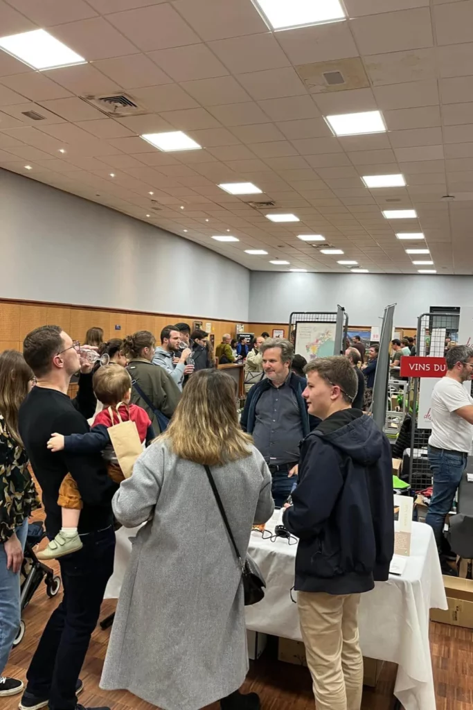 Salon du Vin Bio d’Annecy - Visiteurs nombreux entre les stands, une famille avec un enfant au premier plan