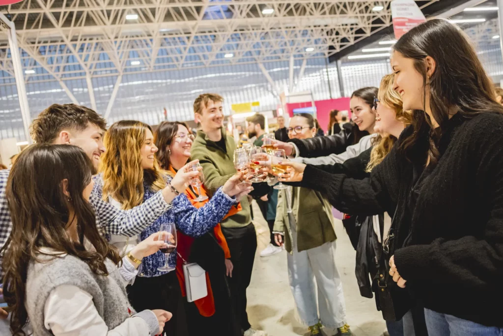 Salon Vins & Terroirs de Toulouse - Visiteurs trinquant sous la charpente métallique du hall